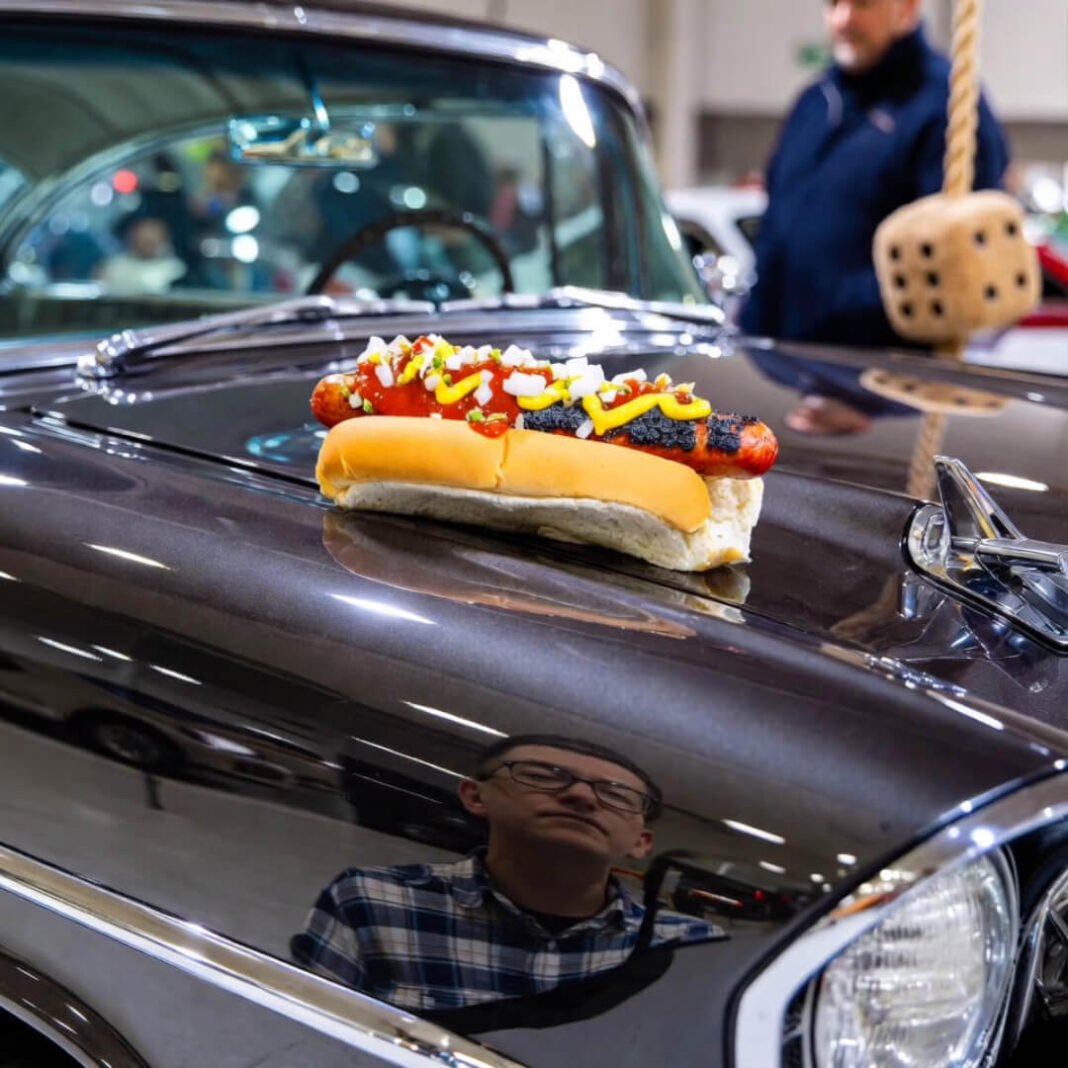 Exhausted man reflected in '57 Bel Air with dying coney dog.
