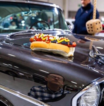 Detroit Auto Show 2024: The Most Stunning Classic Cars on Display Exhausted man reflected in '57 Bel Air with dying coney dog.